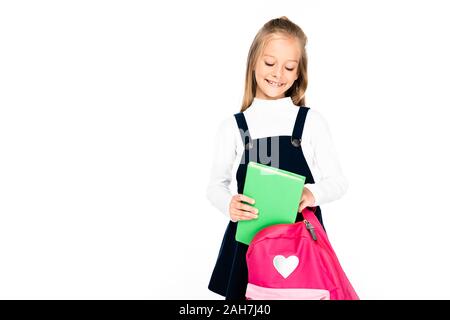 Adorable lycéenne sourire tout en mettant en réserve en sac à dos isolated on white Banque D'Images