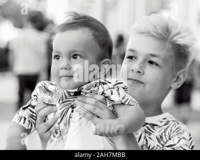 Portrait of caucasian monochrome mignon adorable fratrie garçons se tenant dans la journée ensoleillée à l'extérieur. Famille, aide, support concept Banque D'Images