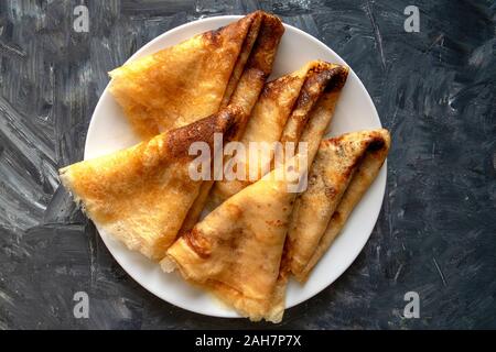 Crêpes fraîches sur fond gris avec espace de copie. Crêpes de style russe pour la semaine traditionnelle du Pancake. Banque D'Images