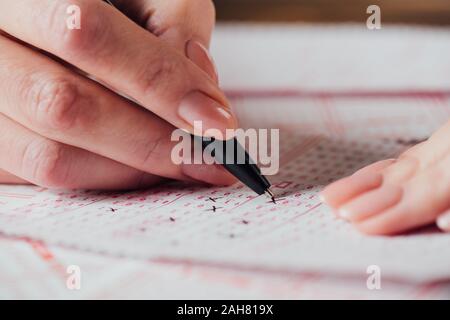 Portrait de femme en nombres de marquage des billets de loterie avec stylet Banque D'Images