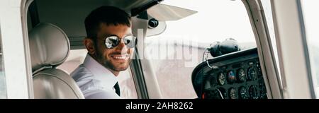 Beau sourire de lunettes de pilote dans l'avion en photo Banque D'Images