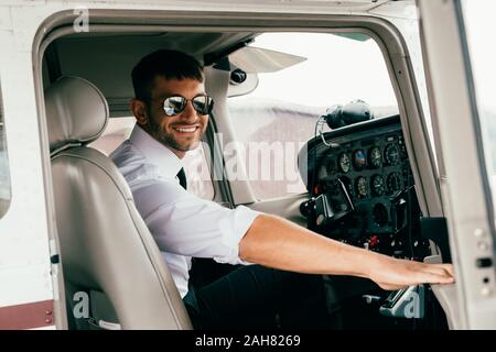 Beau sourire de pilote de lunettes en avion Banque D'Images