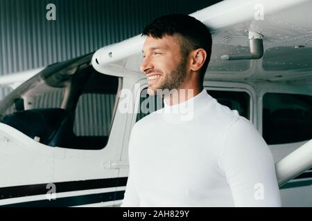 Beau jeune homme en tenue décontractée, debout près de l'avion et à la voiture Banque D'Images