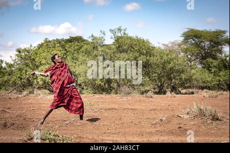 Beau guerrier Massaï jetant sa lance Banque D'Images