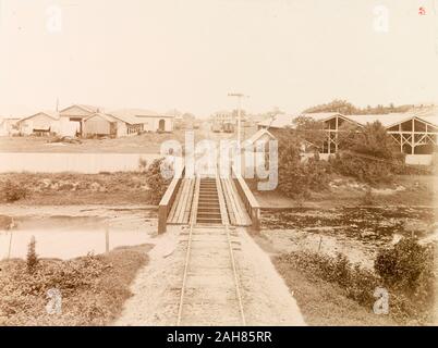 Trinité-et-Tobago, une voie ferrée traverse une rivière pont sur son approche de la gare terminus à Port of Spain.sous-titre suivant : Port of Spain du pont de la rivière à sec, [c.1895]. 1999/221/1/25/3. Banque D'Images