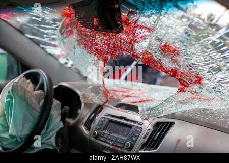 Pare-brise de voiture cassée après un accident avec des traces de sang et de l'airbag. vue de l'intérieur Banque D'Images