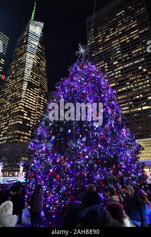Un arbre de Noël brille sur le village d'hiver et de vacances boutiques au Bryant Park de New York. Banque D'Images