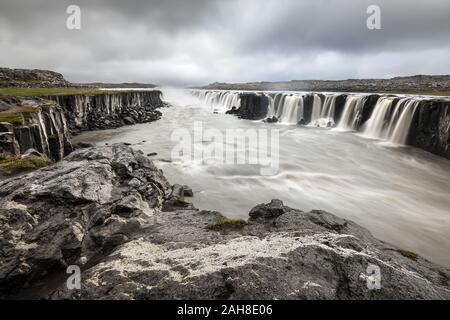 Vue grand angle de la cascade islandaise de Selfoss, sous un ciel gris nuageux menaçant Banque D'Images