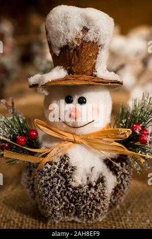 Gros plan d'un bonhomme de neige drôle de noël portant un chapeau haut de gamme et ayant des balais de boucher comme bras Banque D'Images