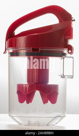 Poubelle transparent rouge pour aspirateur sur un fond blanc. Banque D'Images