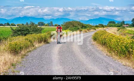 Delta, Colombie-Britannique, Canada - le 20 juillet 2019. Un jeune homme monte un vtt sans casque, sur une route de gravier dans un cadre rural près de Vancouver. Banque D'Images