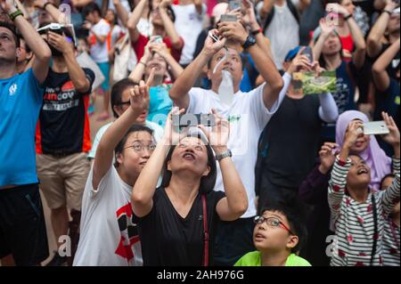 26.12.2019, Singapour, République de Singapour, en Asie - les gens se rassemblent à Kebun Baru Springs Amphitheatre pour observer l'éclipse solaire annulaire. Banque D'Images
