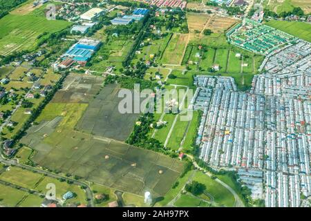 Vue aérienne de l'expansion urbaine dense en raison d'une forte croissance démographique dans les terres agricoles de l'agriculture sur l'île de Luzon aux Philippines. Banque D'Images