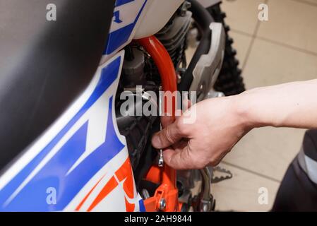 Motocycliste, remplace la bougie de chèques dans une moto. Remplacement de l'étincelle dans l'atelier de réparation. Banque D'Images