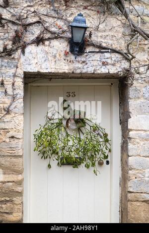 Le gui accroché sur une porte dans cotswold cottage Coln St Aldwyns. Cotswolds, Gloucestershire, Royaume-Uni Banque D'Images