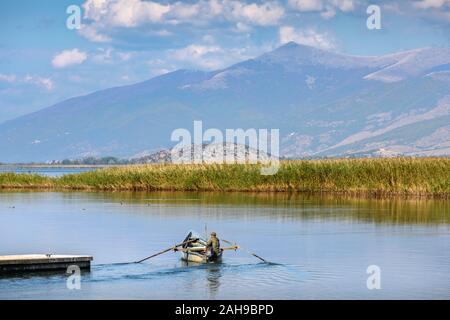 Un pêcheur sur le lac Mikri Prespa au village de Mikrolimni en Macédoine, la Grèce du Nord. Banque D'Images