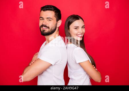 Photo de deux magnifiques à la mode décontractée assez beau genre cheerful personnes debout dos à dos à l'autre portant des t-shirts blancs alors que l'équipe Banque D'Images