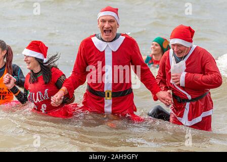 Les nageurs à Santa costume au lendemain de Southend RNLI Rafraîchir nager dans l'estuaire de la Tamise, Southend on Sea, Essex, Royaume-Uni. Hiver froid nager Banque D'Images