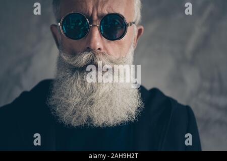 Photo recadrée de smart dures homme masculin en portant des lunettes les lunettes à la veste manteau noir sur fond gris isolé Banque D'Images