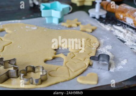 Préparer les biscuits de Noël à l'aide d'un emporte-pièce et d'un rouleau à pâtisserie. Selective focus sur la pâte à biscuit et de coupe Banque D'Images