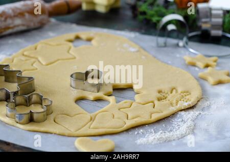 Préparer les biscuits de Noël à l'aide d'un emporte-pièce et d'un rouleau à pâtisserie. Selective focus sur la pâte à biscuit et de coupe Banque D'Images