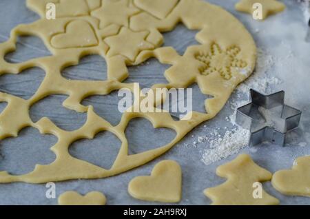 Préparer les biscuits de Noël à l'aide d'un emporte-pièce et d'un rouleau à pâtisserie. Selective focus sur la pâte à biscuit et de coupe Banque D'Images