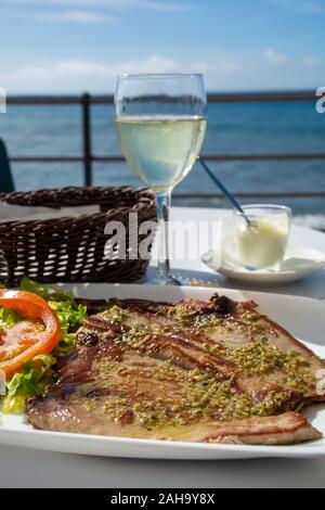 De savoureux fruits de mer, steaks de thon grillé servi avec sauce mojo vert sur terrasse extérieure sur Puerto Naos, La Palma, Canary Islands, Spain Banque D'Images