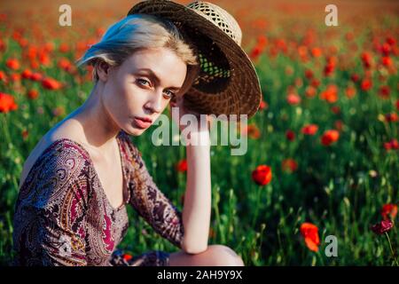 Une agricultrice dans un champ de coquelicots rouges Banque D'Images