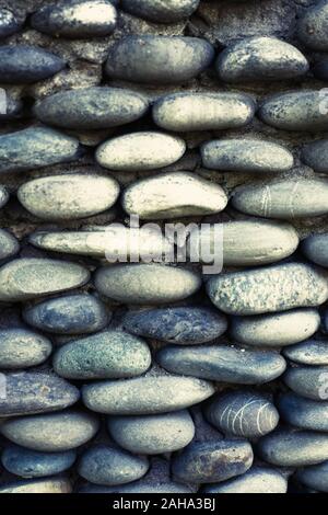 Mur de pierre de cailloux avec du béton en fond de jardin Banque D'Images