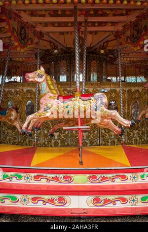 Un cheval peintes de couleurs vives sur un carrousel de foire dans un manège à Brighton, Sussex. Banque D'Images