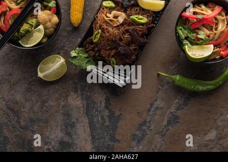 Vue de dessus de nouilles thaï épicé savoureux avec des baguettes sur la surface en pierre Banque D'Images