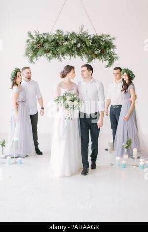 Couple nouvellement marié avec les garçons et les demoiselles posant lors de la cérémonie du mariage. Banque D'Images