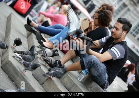 24.05.2017, London, , Grande-Bretagne - Homme nourrir les pigeons à Trafalgar Square. 00S170524D069CAROEX.JPG [communiqué de modèle : Non, des biens : non (c) ca Banque D'Images