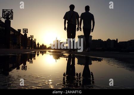 26.03.2018, Dubaï, Emirats Arabes Unis , - Les adolescents se reflètent dans une flaque d'eau au coucher du soleil. 00S180326D279CAROEX.JPG [communiqué de modèle : Non, les biens RELEAS Banque D'Images