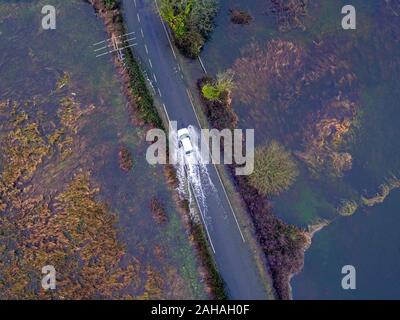 Une voiture conduit par l'eau de l'inondation près de Harbridge, 2,5 milles au nord de Ringwood dans le Hampshire, après la rivière Avon éclater ses banques. Banque D'Images