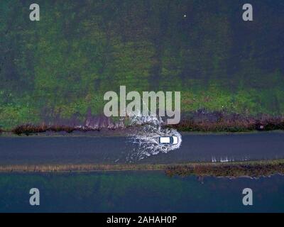 Une voiture conduit par l'eau de l'inondation près de Harbridge, 2,5 milles au nord de Ringwood dans le Hampshire, après la rivière Avon éclater ses banques. Banque D'Images