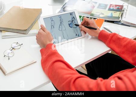 Mains de la création de mode avec stylet pointant sur l'un des nouveaux modèles Banque D'Images