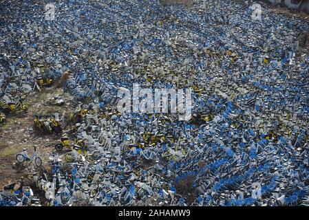 Zhejiang, Chine. Dec 27, 2019. Un grand nombre de vélos partagés abandonnés dans un terrain vague à Hangzhou, Zhejiang Province de Chine orientale. Crédit : SIPA Asie/ZUMA/Alamy Fil Live News Banque D'Images