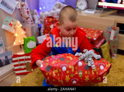 7 ans de l'ouverture d'un cadeau de Noël Banque D'Images