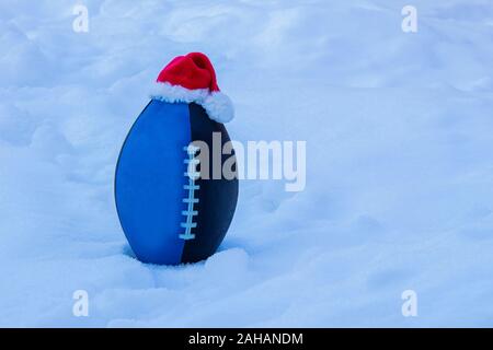 Bleu Noir Le football junior wearing a Santa Claus Hat sur la neige Banque D'Images