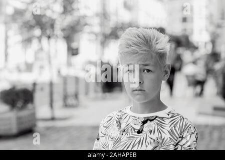 portrait de beau beau blond onze vieux garçon (adolescent) perdu dans la ville. Grandir, puérier, séparer le concept Banque D'Images