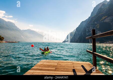 Riva del Garda, Lombardie, Italie - le 12 septembre 2019 : Deux touristes arrivant avec kayak à la jetée sur les rives du lac de garde dans la ville de Riva del Garda je Banque D'Images