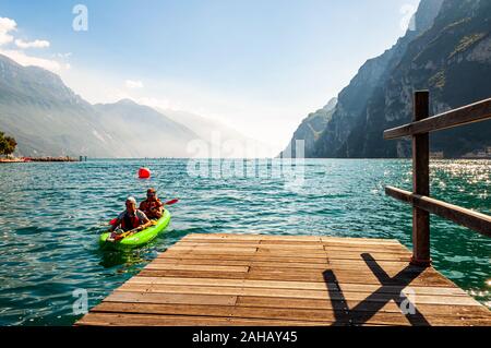 Riva del Garda, Lombardie, Italie - le 12 septembre 2019 : Deux touristes arrivant avec kayak à la jetée sur les rives du lac de garde dans la ville de Riva del Garda je Banque D'Images