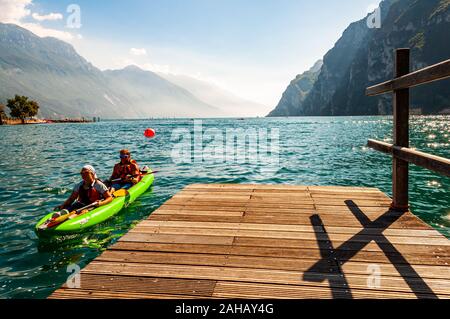 Riva del Garda, Lombardie, Italie - le 12 septembre 2019 : Deux touristes arrivant avec kayak à la jetée sur les rives du lac de garde dans la ville de Riva del Garda je Banque D'Images