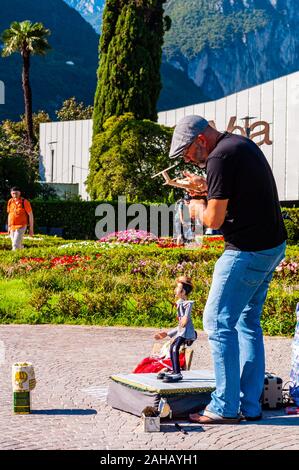 Riva del Garda, Lombardie, Italie - le 12 septembre 2019 : l'artiste marionnettiste jouant avec sa poupée sur la promenade du lac de garde dans la ville de Riva del Garda Banque D'Images