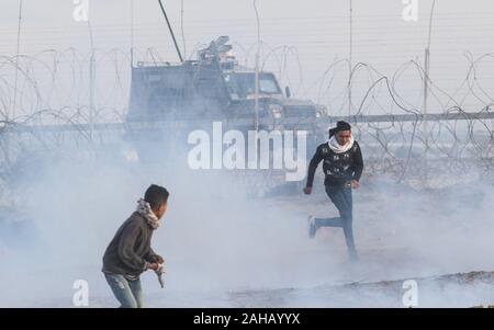 Rafah, Gaza. Dec 27, 2019. Les forces israéliennes de sécurité incendie des gaz lacrymogènes lors d'affrontements avec des manifestants palestiniens lors d'une manifestation le long de la frontière avec Israël à l'est de Rafah dans le sud de la bande de Gaza. le vendredi, Décembre 27, 2019. Les Palestiniens de Gaza, manifestations retour le long de la frontière fortifiée avec Israël, des factions dans la bande de Gaza, a déclaré jeudi, Photo par Ismael Mohamad/UPI UPI/Alamy Crédit : Live News Banque D'Images