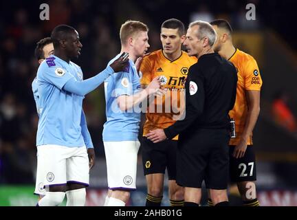 Les joueurs parlent à l'arbitre Martin Atkinson que Manchester City's Benjamin Mendy (à gauche) est titulaire d'un objet qui a été jeté sur le terrain au cours de la Premier League match à Molineux, Wolverhampton. Banque D'Images