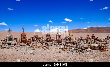 Tombes dans le cimetière désert à l'extérieur de l'établissement minier abandonné à distance ville fantôme de Mina La Casualidad, dans le désert de haute altitude de l'altiplano de la puna de la province de Salta, dans le nord de l'Argentine Banque D'Images