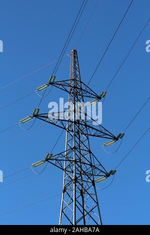 L'utilitaire de ligne de puissance importante hauteur mât, de tuyaux en métal avec 7 fils électriques connectés avec les isolateurs de verre transparent sur ciel bleu clair Banque D'Images