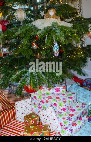 Pile de traditionnelle colorée typique de Noël ou des cadeaux emballés présente sous un arbre de Noël au Royaume-Uni des fêtes Banque D'Images